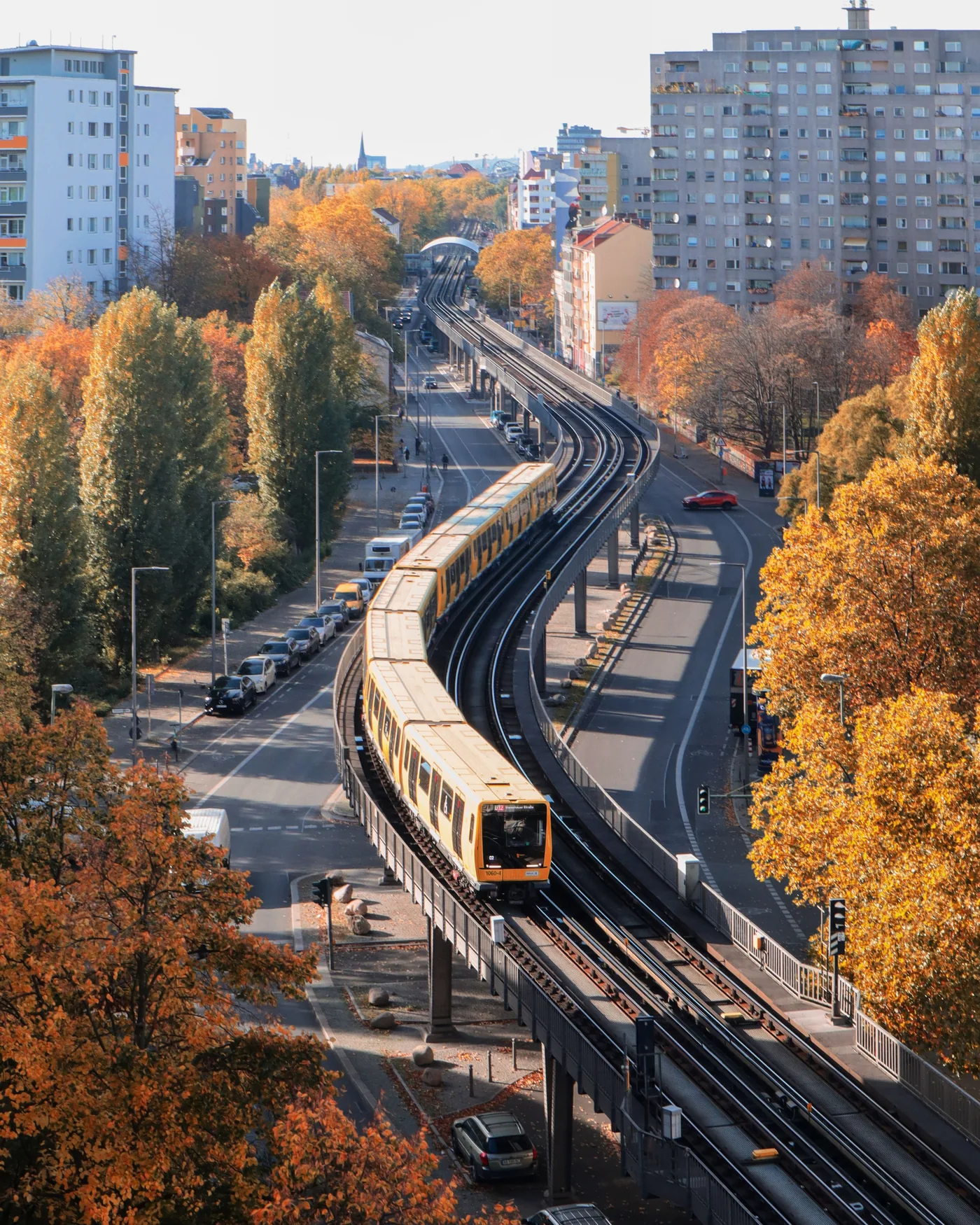 Gelbe Berliner U-Bahn zwischen Wohngebäuden in einem innerstädtischen Quartier