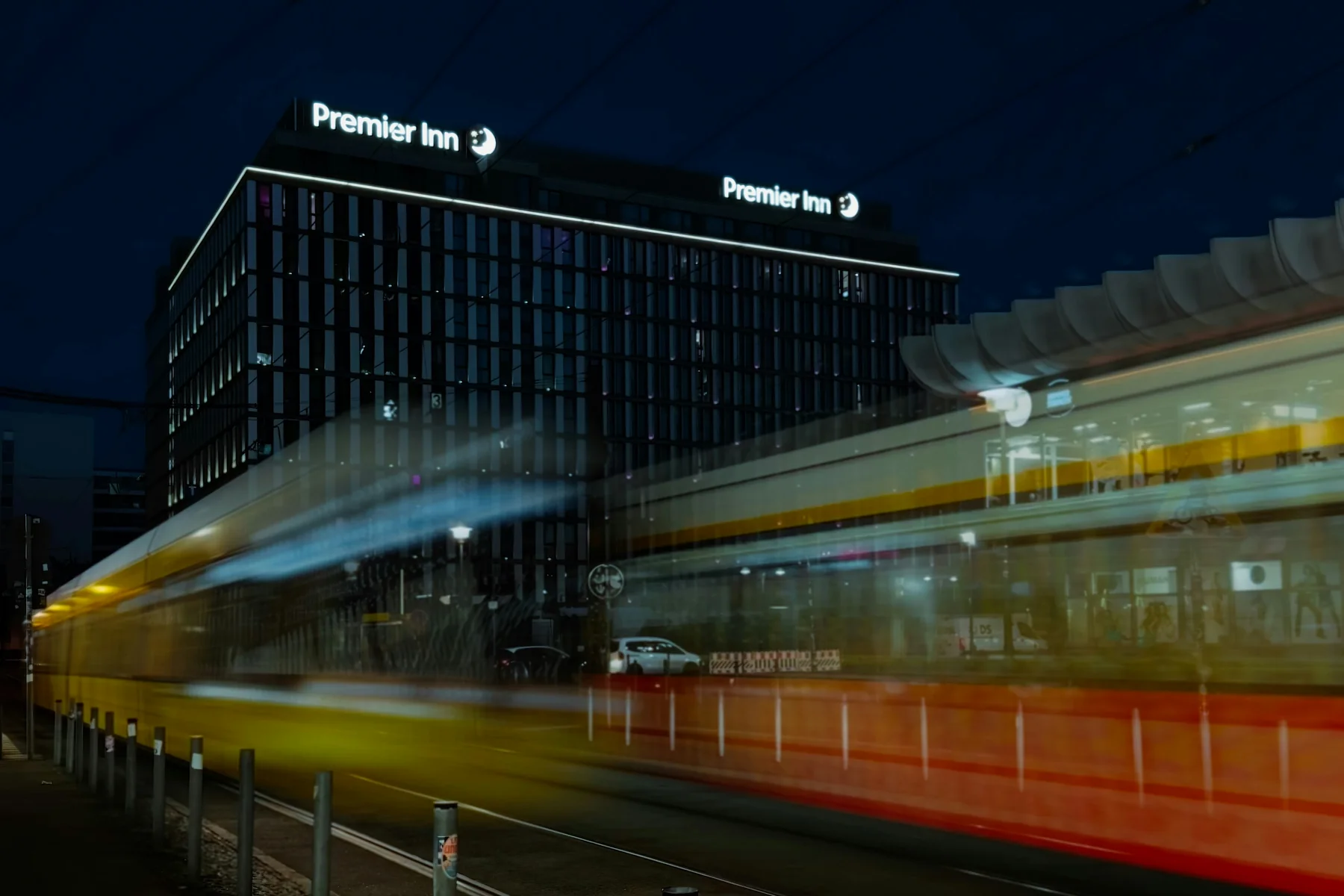 Hotelgebäude in Berlin mit vorbeifahrender Straßenbahn im direkten Stadtumfeld